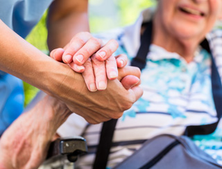 senior care nurse holds hands of elderly woman in southeast michigan